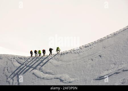 Climbers on the arete leading up from the Vallee Blanche to the Aiguille Du Midi above Chamonix, France. Stock Photo