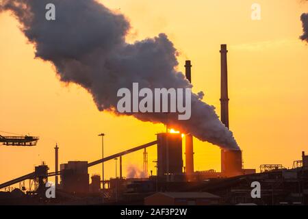 Emissions from a Tata steel works in Ijmuiden, Netherlands, at sunset. Stock Photo