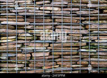 Close up of gabion retaining wall, constructed of a wire cage and stone stacked inside. Stock Photo