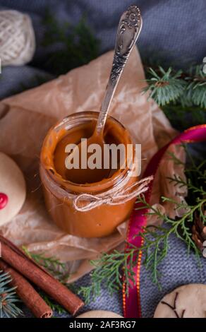 Tasty and fragrant chocolate chip cookies are crushed with powdered sugar, with multi-colored lights on the table. Merry Christmas Stock Photo