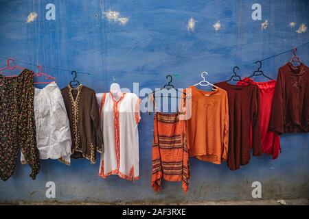 Moroccan clothes hang on a wall in Chefchaouen Stock Photo