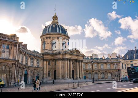 Paris, France - November 7, 2019: French Institute of Sciences, and the Mazarine library, in front of the bridge of the Arts and the Louvre museum Stock Photo