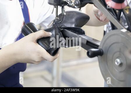 Cropped image of young shoemaker in workshop making shoes. Stock Photo