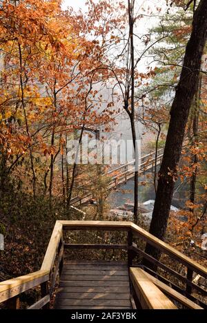 Wood staircase leading down the mountain to the suspension bridge that crosses the Tallulah River at the Tallulah Gorge State Park in Georgia USA. Stock Photo