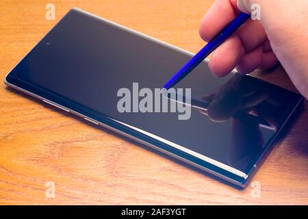 PIATRA NEAMT, ROMANIA - NOVEMBER 25, 2019: Typing hand on smartphone display, Samsung Galaxy Note 10 Stock Photo
