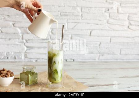 Green tea matcha iced latte with almond milk on light background. Healthy eating concept. Copy space. Stock Photo