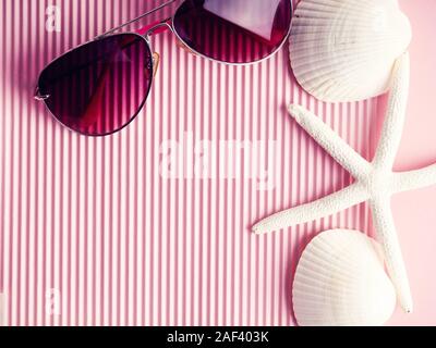 sunglasses and seashells on a pink ribbed background. space for text, postcard for design Stock Photo