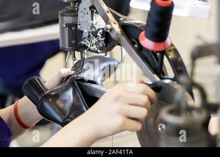Cropped image of young shoemaker in workshop making shoes Selected focus. Stock Photo
