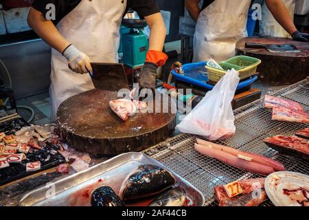 Vendor cuts fish on food market in HongKong, Stock Photo