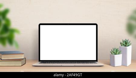 Laptop computer mockup on work desk. Close-up scene with plants and books on table. Modern, thin laptop design. Isolated screen for mockup, app or web Stock Photo