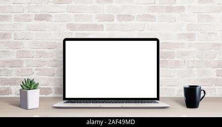 Laptop mockup on simple, clean desk with brick wall in background. Isolated screen for ap, web site resentation. Plant and cup of coffee on table Stock Photo