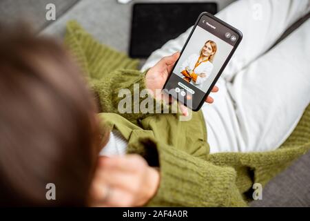 Woman talking with a doctor online using smartphone, feeling bad at home, close-up on phone screen. Concept of telemedicine and patient counseling online Stock Photo