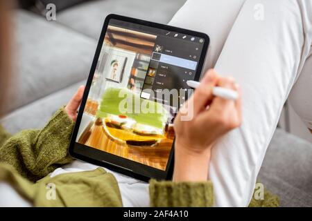 Artist or designer drawing interior sketch using digital tablet and wireless pencil at home, close-up on a screen. Designing on digital touchpads concept Stock Photo