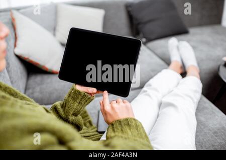 Mockup image of digital touchpad with empty screen to copy paste in woman's hands, lying on the couch at home Stock Photo