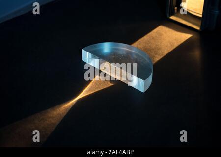 Physics experiment. Passing of a lightbeam through a positive lens, showing a convergent pattern. Light comes together in focal point. Stock Photo