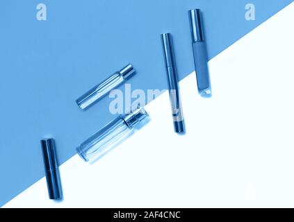 Flat lay composition with decorative makeup products and parfume on trendy blue and isolated white background. Makeup and beaty concept. Color of the Stock Photo