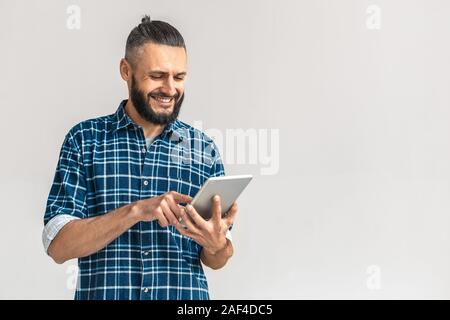 Mature bearded man smiling, using tablet computer Stock Photo