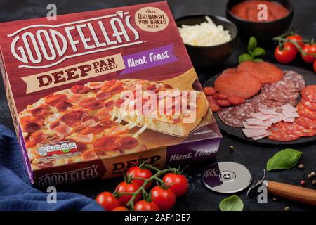 LONDON, UK - NOVEMBER 20, 2019: Box of Goodfella's Deep Pan BakedMeat Feast pizza with salami, cheese and tomatoes on black background. Stock Photo