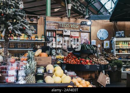 London, UK - November 29, 2019: Woman working at the Teds Veg stall in Borough Market, one of the largest and oldest food markets in London. Stock Photo