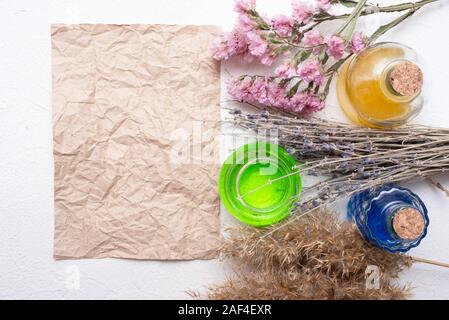 Old magic scroll with copy space, dried herbs and bottles of magic potion on mage table. Stock Photo