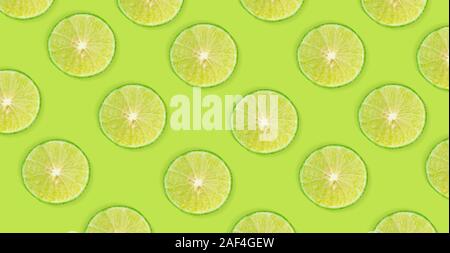 Fruit pattern of lime slices isolated on green background Stock Photo