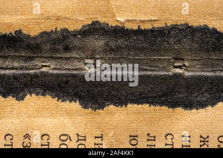 Spilled ink on the fold of a USSR textbook. Sheet texture of the old Soviet book. Background Stock Photo