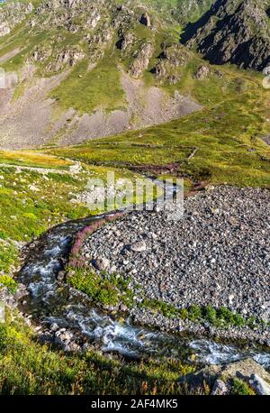 Kaçkar Mountain summit climb starts in Yusufeli Yaylalar Village. Mountaineers are walking in the greenery and on the track accompanied by a stream Stock Photo