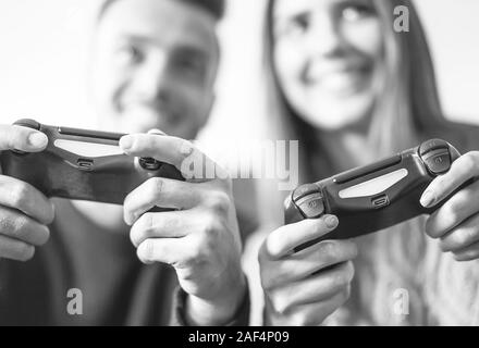 Excited couple playing video games at home - Happy young people having fun with new online trends technologies Stock Photo