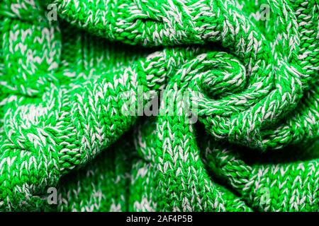 Knitted Sweater Background Twisted into a Spiral. Green white mottled pattern. Facial surface. Copy space Stock Photo