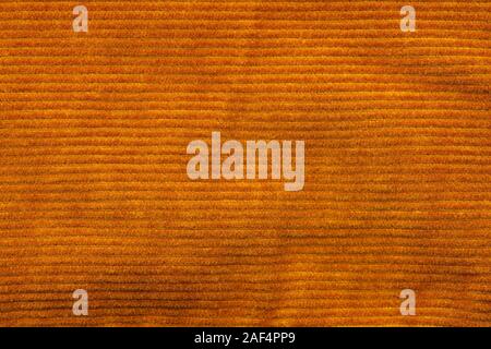 Texture of corduroy velvet fabric close-up. Texture of rufous velvet clothes. Textile fabric as background Stock Photo