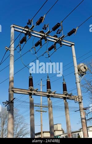 Closeup of high voltage overheard electrical power lines and insulators ...