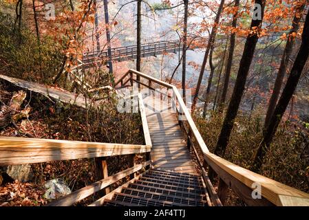 Wooden walkway leading towards a suspension bridge that crosses over the Tallulah River in Tallulah Falls Georgia USA. Stock Photo