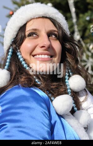 portrait of young attractive woman dressed as Snow Maiden near the Christmas tree Stock Photo