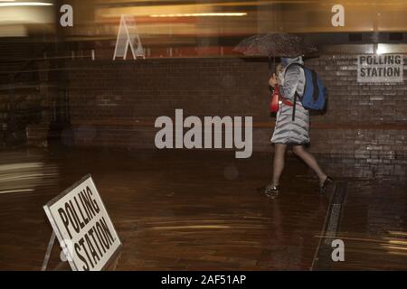 London, UK. 12th Dec, 2019. In the evening rain, voters stream to City of London Girls School, City of London's Ward of Cripplegate, to cast their vote in 2019 general election that will decide the next steps in Brexit, City of London, UK. Credit: Veronika Lukasova/ZUMA Wire/Alamy Live News Stock Photo