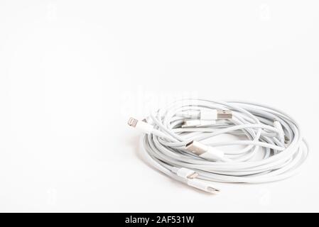 Vidalia, Georgia / USA - September 8, 2019: Several white Apple power cables and connectors in an organized swirl on plain white background. Stock Photo