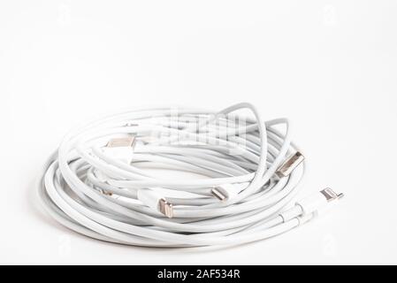 Vidalia, Georgia / USA - September 8, 2019: Several white Apple power cables and connectors in an organized swirl on plain white background. Stock Photo