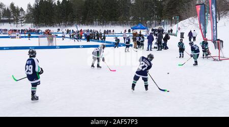 Youngsters playing ice hockey on an exterior rink. Centre de la Nature, Laval, province of Quebec, Canada. Stock Photo