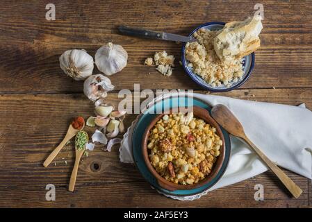 Still life with bread on a dark wooden background, crumbs with sausage. Dark food photography Stock Photo