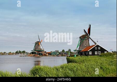 View of traditional Dutch windmills along the canal in spring at the Zaanse Schans, Zaandam, Netherlands Stock Photo