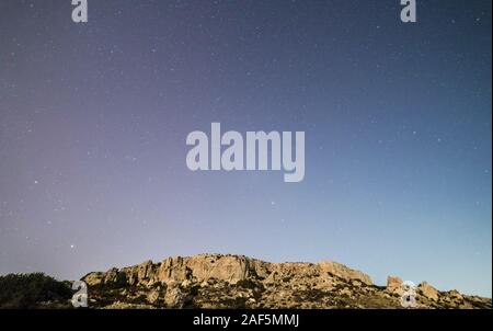 The cliff face at Mgiebah Bay in Malta, under a starry sky. Stock Photo