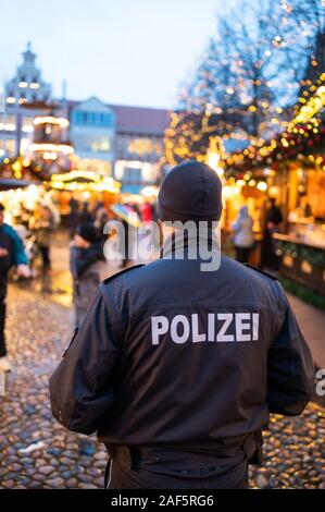 11 December 2019, Lower Saxony, Lüneburg: A policeman is standing at the Christmas market in front of the city hall. Photo: Philipp Schulze/dpa Stock Photo