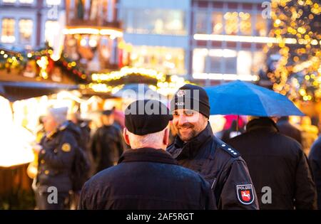 11 December 2019, Lower Saxony, Lüneburg: The policeman, Kai Richter, talks to a visitor from the Lüneburg Christmas market. (to dpa 'Mustard trick and tree theft: Crime scene Christmas market') Photo: Philipp Schulze/dpa Stock Photo