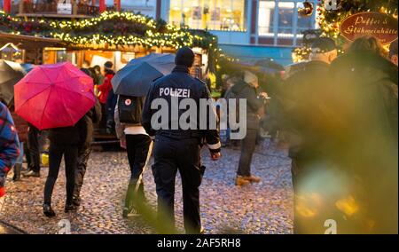 11 December 2019, Lower Saxony, Lüneburg: A policeman walks over one of Lüneburg's Christmas markets. (to dpa 'Mustard trick and tree theft: Crime scene Christmas market') Photo: Philipp Schulze/dpa Stock Photo