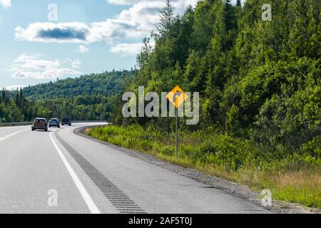 Vehicles on the road curve with warning slight bend or curve in the road  ahead to the right sign, a Canadian rural road between forests Stock Photo  - Alamy