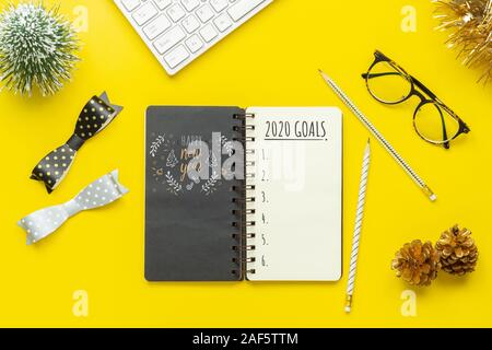 2020 New Year Resolution Goals List Concept. Business office desk with notebook written in handwriting about plan listing of new year goals and resolu Stock Photo