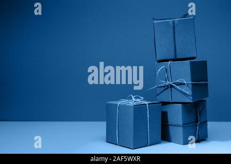 Craft cardboard boxes on the solid classic blue background. Holiday and gift concept. Horizontal Stock Photo