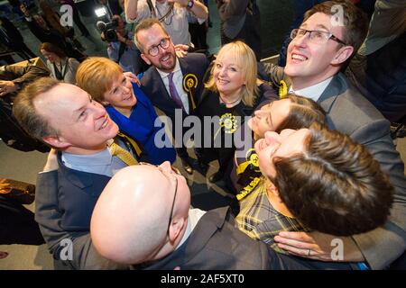 Glasgow, UK. 13th Dec, 2019. Pictured: (in blue) Nicola Sturgeon MSP - First Minister of Scotland and Leader of the Scottish National Party (SNP); standing along with hre winning candidates. Scenes from the vote count at the Scottish Exhibition and Conference Centre (SECC). The poles have now closed at 10pm and the vote count is now underway for the UK Parliamentary General Election 2019. This is the first time in almost 100 years that a general election has taken place in December. Credit: Colin Fisher/Alamy Live News Stock Photo