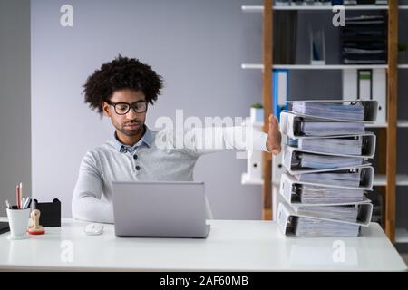 Businessperson Pushing Paper Documents Away And Working With Digital Documents On Computer Instead Stock Photo