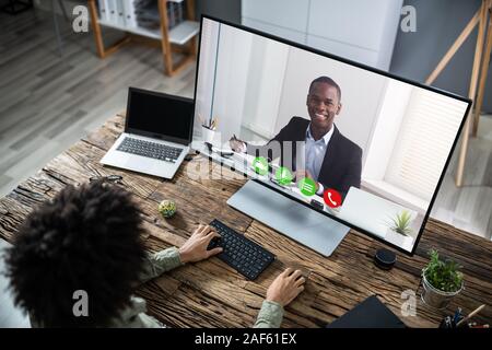 Businessman Sitting At A Desk Watching An Online Presentation On The Computer Stock Photo