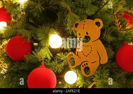 Wooden Little Bear Ornament with Red Christmas Ball on the Christmas tree Stock Photo